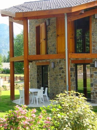 a wooden pavilion with a table and chairs in a yard at Les Granges de Leo in Aston