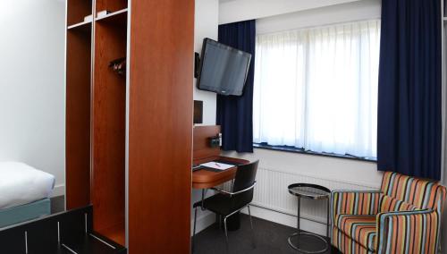 a hotel room with a desk and a tv at Amrâth Hotel Eindhoven in Eindhoven