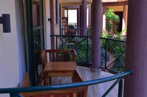 a porch with a wooden table and chairs on a balcony at Nile Village Hotel & Spa in Jinja
