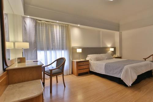 Habitación de hotel con cama, escritorio y silla en Gran Hotel Parana en Paraná