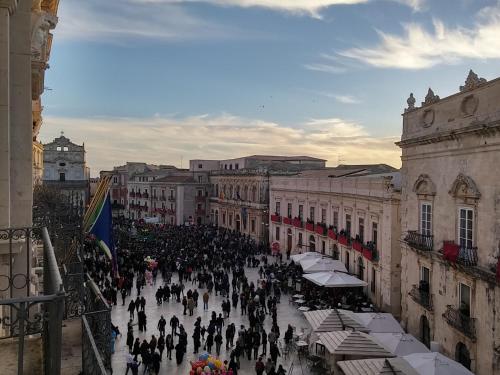 a crowd of people walking down a city street at D-Home Ortigia in Siracusa