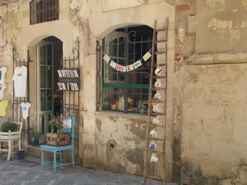 a building with a window with a shelf with mugs at D-Home Ortigia in Siracusa