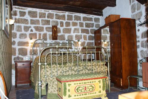 Cama de metal en una habitación con pared de piedra en La scaletta, en Bolsena