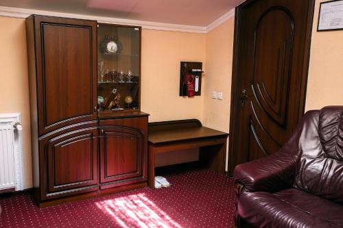 a room with a desk and a large wooden cabinet at Edem Hotel Lviv in Lviv