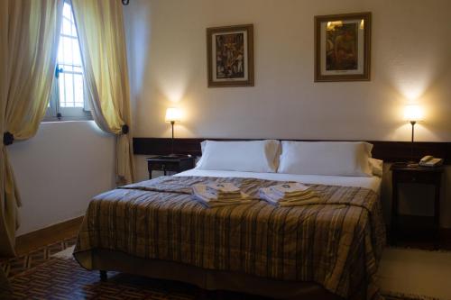 a bedroom with a bed with two lamps and a window at Boutique Hotel Sevilla in La Cumbre
