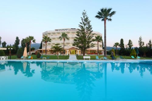 a large swimming pool with a hotel in the background at Regina Hotel in Kissamos