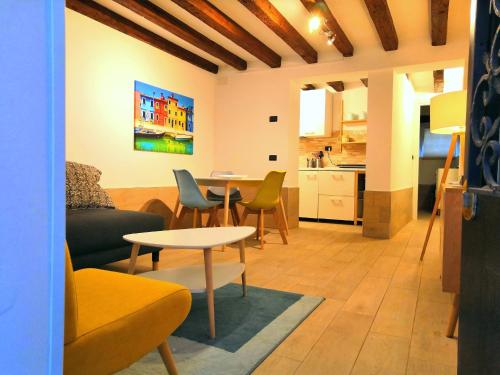 uma sala de estar com um sofá, uma mesa e uma cozinha em Appartamento AlCova em Veneza