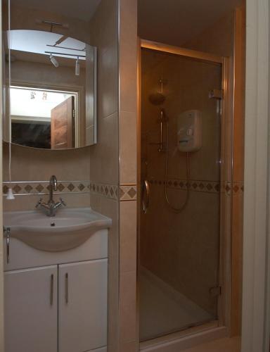 a bathroom with a shower and a sink and a mirror at 2 bedrooms Bell Cottage in Hoddesdon