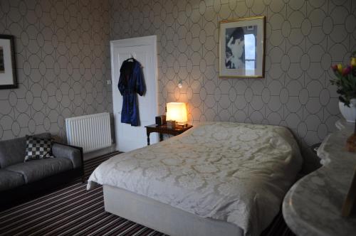 a bedroom with a bed and a chair and a lamp at Aberley House in Liverpool
