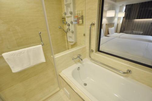 高雄的住宿－康橋商旅-七賢館，带淋浴、盥洗盆和镜子的浴室