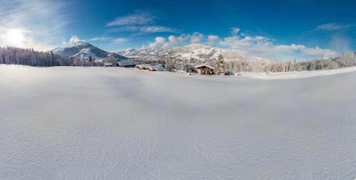 a snow covered mountain with a house in the distance at Berggasthof Staudachstub'n in Kirchberg in Tirol