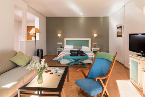 a living room with a bed and a couch at Parador de Ayamonte in Ayamonte