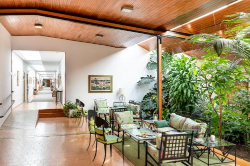 an indoor patio with tables and chairs and plants at Parador de Ayamonte in Ayamonte