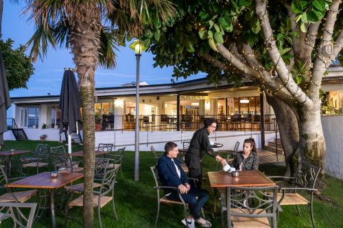 a group of people sitting at tables in a park at Parador de Ayamonte in Ayamonte
