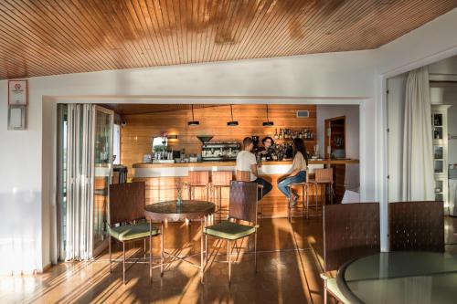 two people sitting at a bar in a kitchen at Parador de Ayamonte in Ayamonte