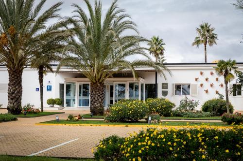 a building with palm trees in front of it at Parador de Ayamonte in Ayamonte