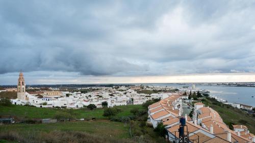 a city with white buildings on a hill next to the water at Parador de Ayamonte in Ayamonte