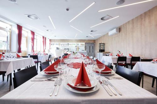 a dining room with a long table with red napkins at Penzion U Zámku in OÅ™echov