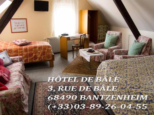 a hotel room with two beds and chairs and a table at Hôtel de Bâle in Bantzenheim