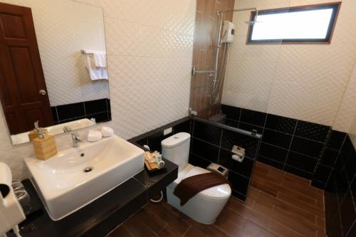 a bathroom with a sink and a toilet and a mirror at The Scene Cliff View Villas in Ao Nang Beach