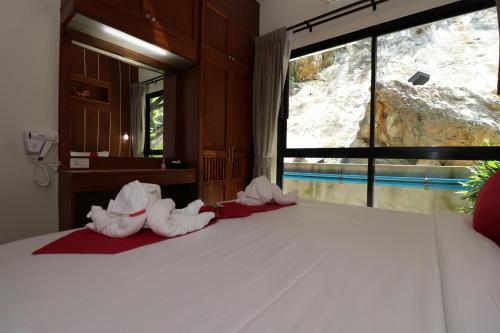 a bedroom with a bed with towel animals on it at The Scene Cliff View Villas in Ao Nang Beach