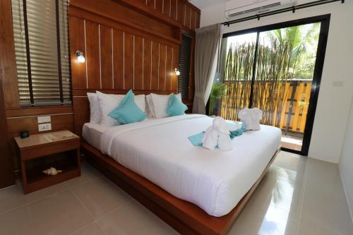 a bedroom with a bed with two teddy bears on it at The Scene Cliff View Villas in Ao Nang Beach