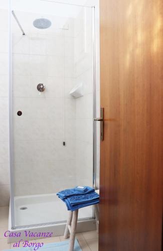 a shower with a blue towel on a stool in a bathroom at Casa Vacanze Al Borgo in Caprino Veronese