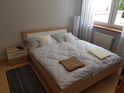 een slaapkamer met een bed met twee handdoeken erop bij Apartament z ogródkiem Pomerania in Kołobrzeg