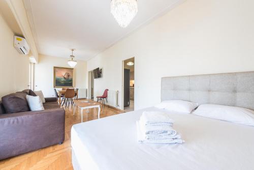 - une chambre avec un lit blanc et un salon dans l'établissement Victoria Capitan Apartments, à Athènes