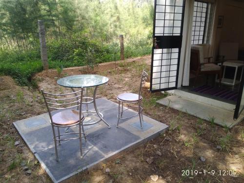 a table and two chairs sitting outside of a house at Isai Ambalam guest house in Puducherry