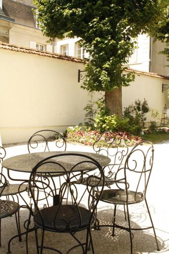 a group of tables and chairs with a tree at LA MONGEARDIERE in Ay