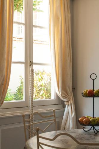 a room with a window and a table with a bowl of fruit at LA MONGEARDIERE in Ay