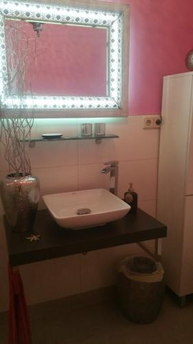 ein Badezimmer mit einem Waschbecken und einer rosa Wand in der Unterkunft Ferienwohnung Halle Saale in Halle an der Saale