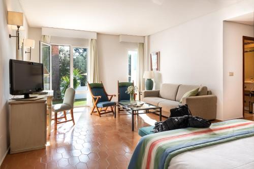 
a living room filled with furniture and a tv at Parador de Ayamonte in Ayamonte
