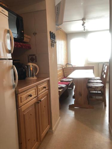 une cuisine et une salle à manger avec une table et un réfrigérateur dans l'établissement Lauzes, aux Menuires