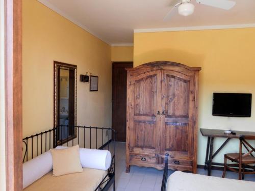 a room with a wooden door and a tv at Hotel Il Caminetto in Portoferraio