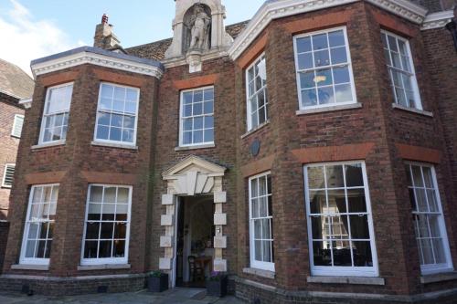 a brick building with white windows and a tower at Bank House in King's Lynn