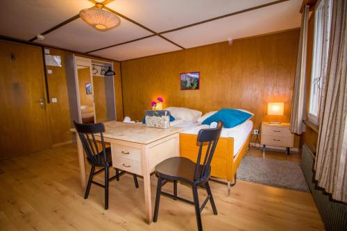 a bedroom with a bed and a table and chairs at Hotel Hornerpub in Lauterbrunnen