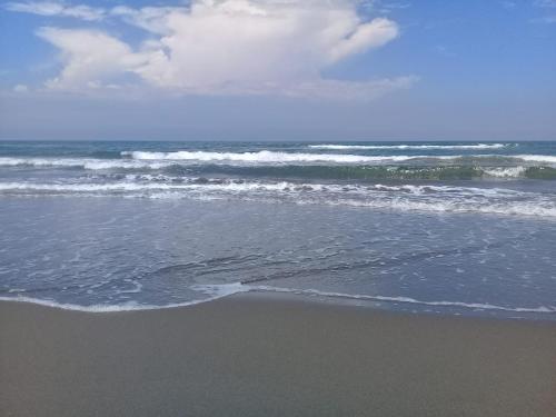 a sandy beach with waves in the ocean at Hotel La Estrella Polar in Costa Esmeralda