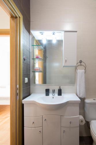 ein Badezimmer mit einem weißen Waschbecken und einer Toilette in der Unterkunft KHouses Maissonette in Lefkada Town