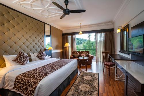 a hotel room with a large bed and a television at Century Pines Resort Cameron Highlands in Cameron Highlands