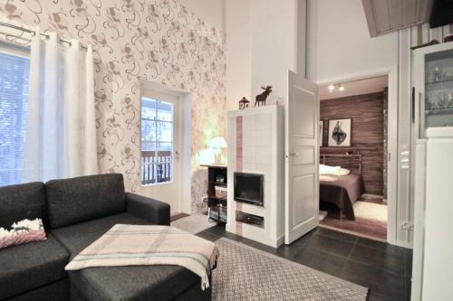 - un salon avec un canapé et une chambre dans l'établissement Levin Rölli - Apartment 4, à Levi