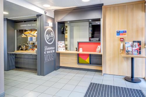 a fast food restaurant with a fast food counter at B&B HOTEL Orgeval in Orgeval