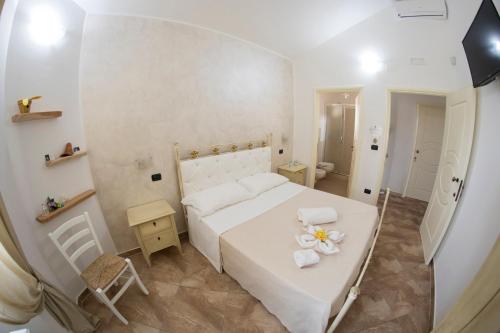 a bedroom with a bed and a table with flowers on it at Blue And Blue City in Ugento