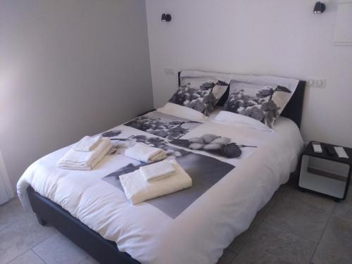 ein Bett mit einem schwarz-weißen Bild darauf in der Unterkunft Le Jasmin in Montagnac