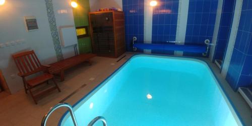 a bathroom with a swimming pool with a bench and a chair at Apartmány Batelov in Batelov