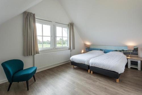 a bedroom with a bed, chair, desk and a window at Buitenplaats Witte Raaf aan Zee in Noordwijk