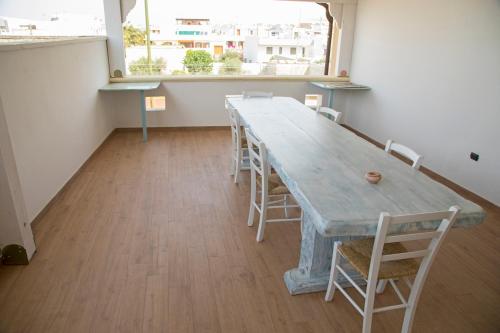 a long table and chairs in a room with a window at Blue And Blue City in Ugento