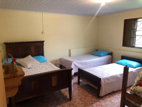 Cette chambre comprend 2 lits, une table et 2 lits. dans l'établissement Sítio Tapera em Ibitipoca - MG, com Wi-Fi, à Conceição da Ibitipoca