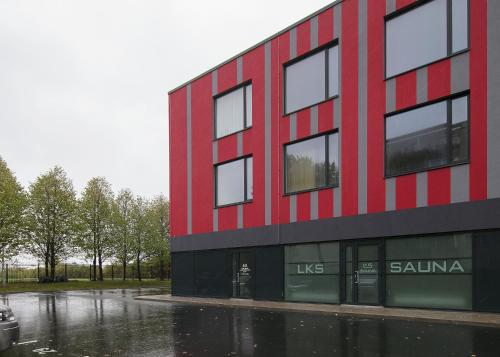 a red and black building on a rainy street at LKS Apartment 4 in Tallinn